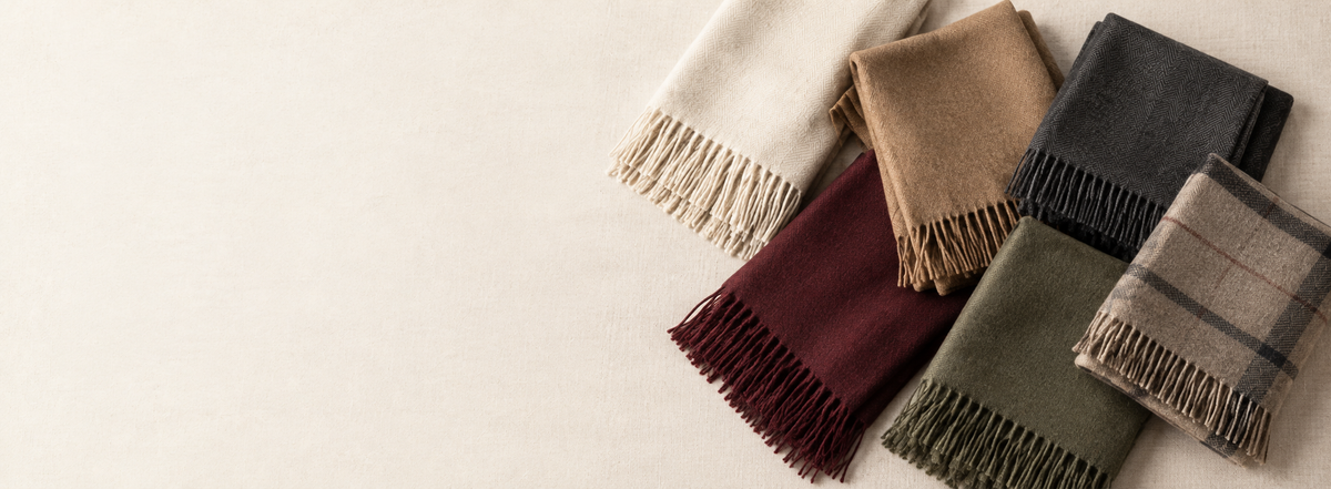 Folded winter shawls and stoles in cream, camel, charcoal, maroon and olive